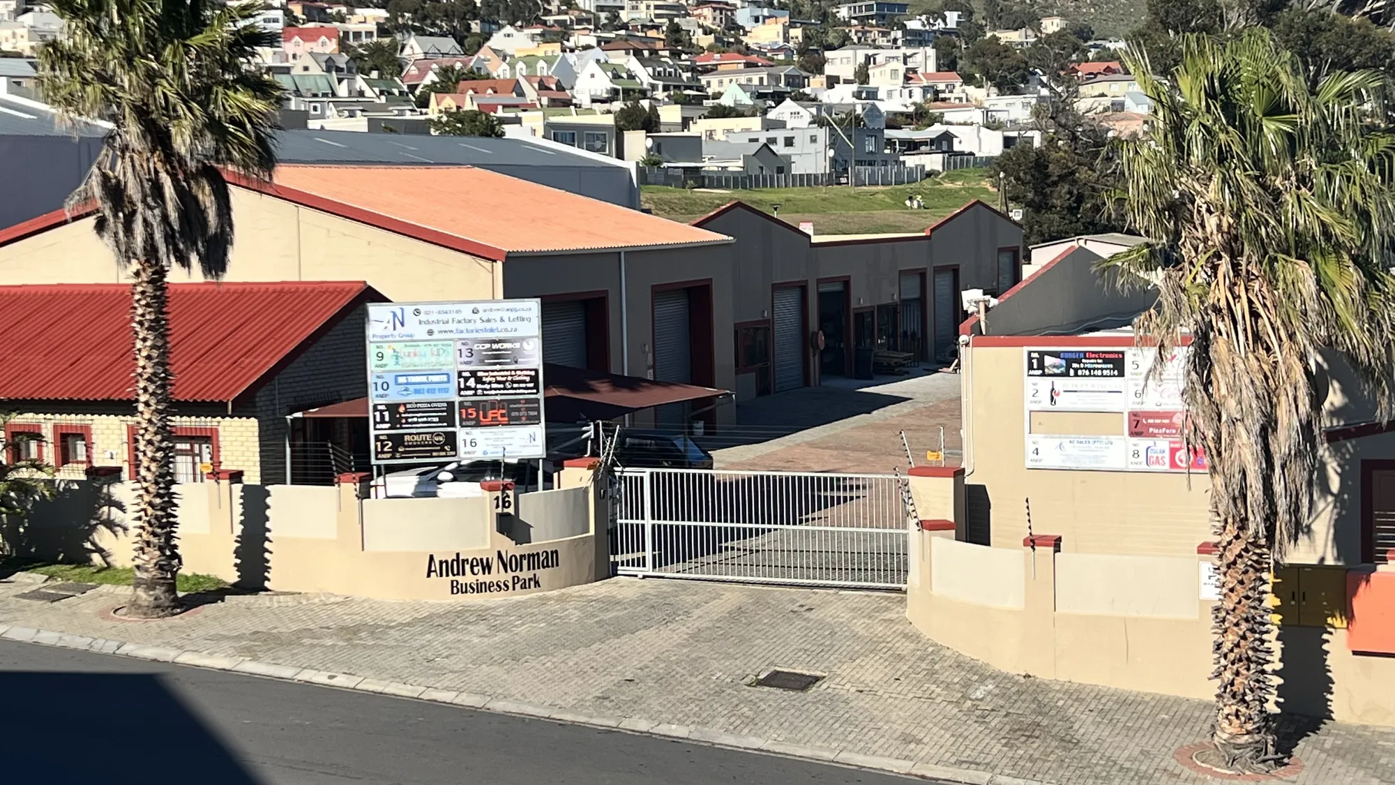The park entrance on Industria Road, with its sign, gate and palm trees