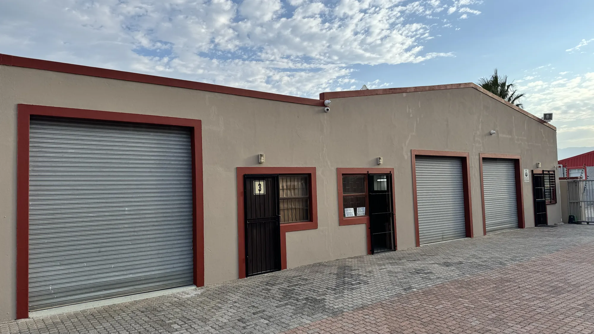 A unit with a roller door and a barred front door
