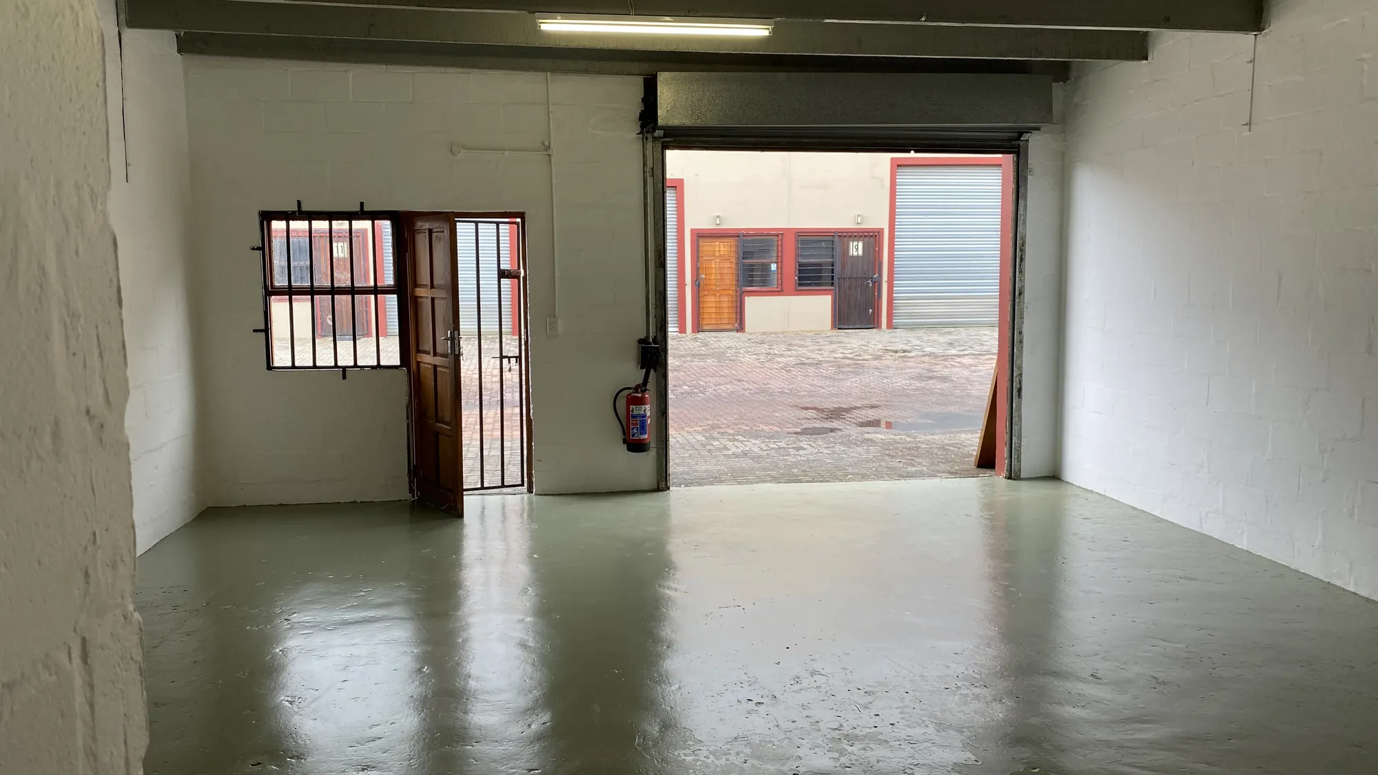 Inside an empty unit, looking out through the open roller door