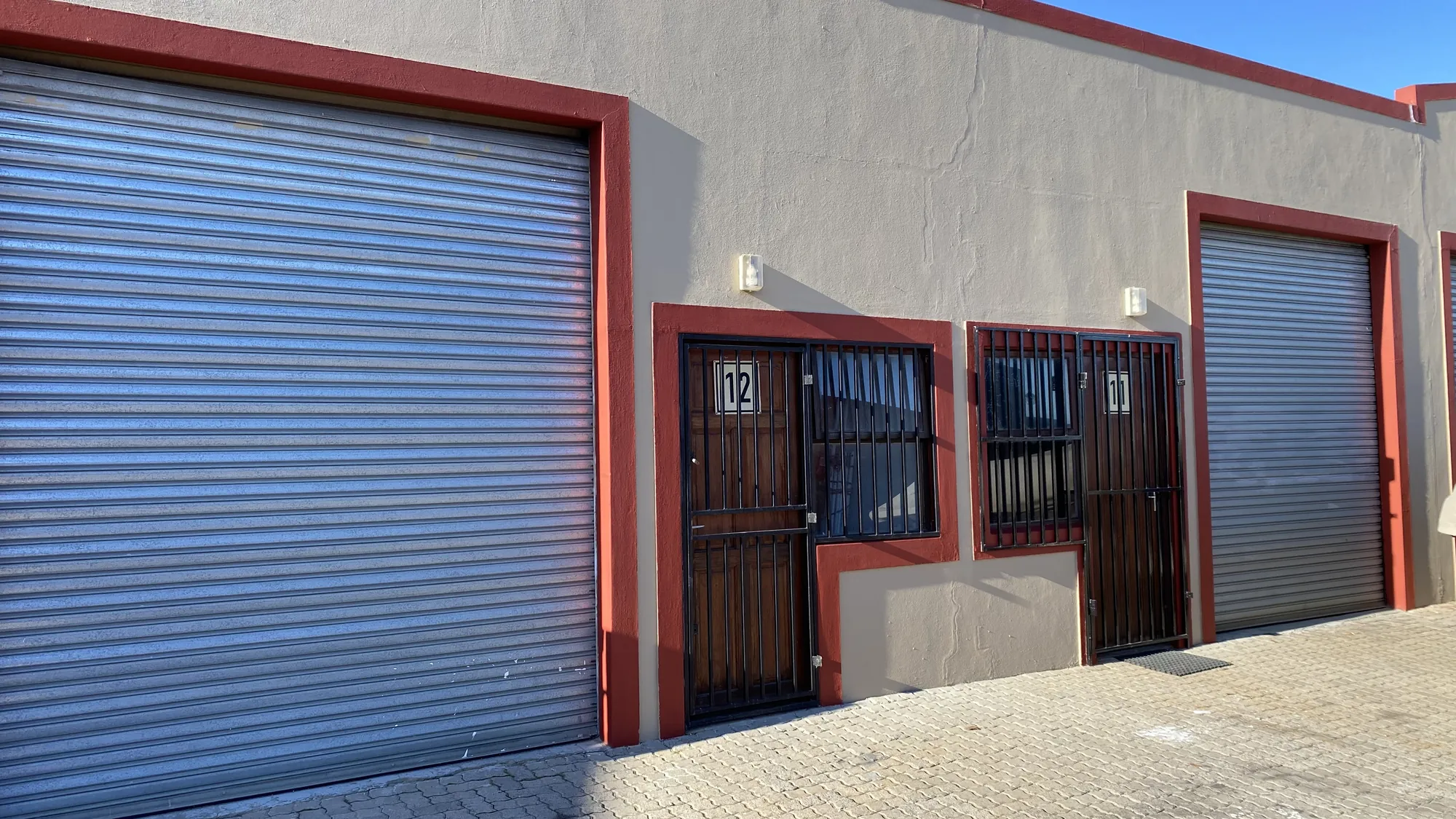 Units 2 and 3, each with a roller door and a barred front door
