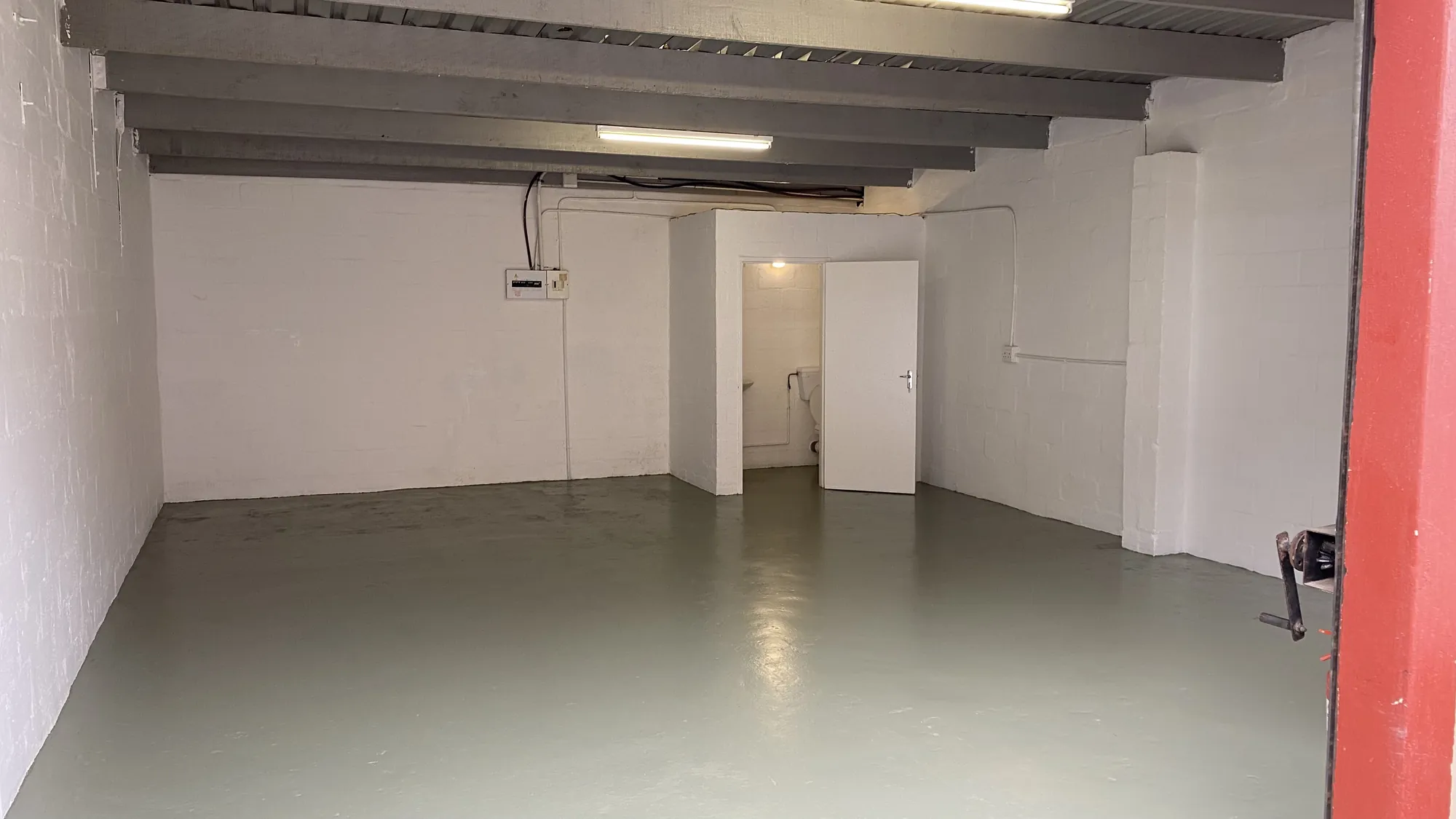Inside a unit: painted floor, white walls and overhead lighting