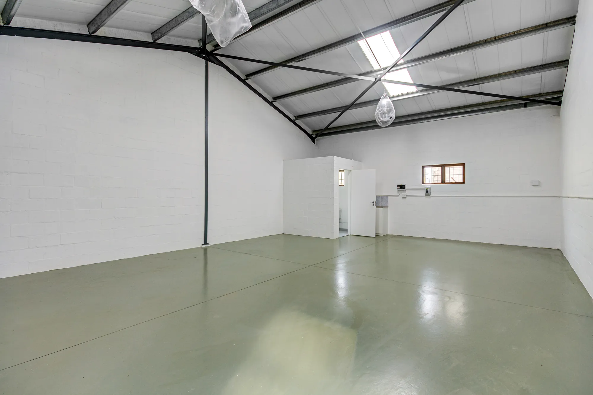Inside a unit: high steel trusses, skylights and a painted floor